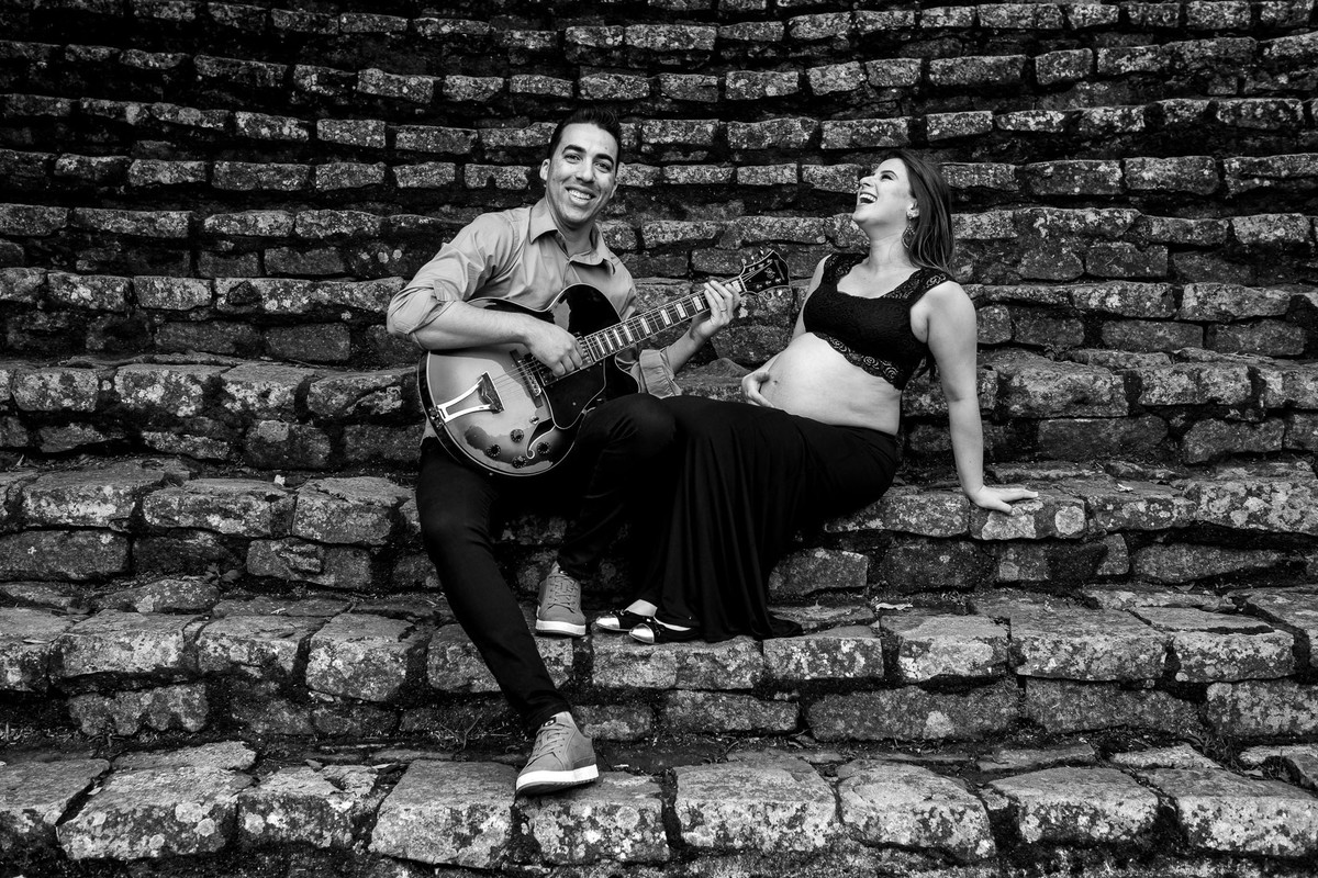 casal gestante sentados tocando guitarra no jardim botânico em são paulo